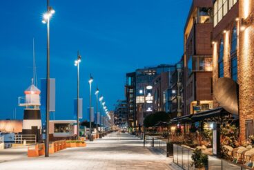 Oslo, Norway. Night View Embankment And Residential Multi-storey Houses In Aker Brygge District. Summer Evening. Residential Area Reflected In Sea Waters. Famous And Popular Place.