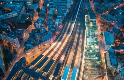 London. Train station and Tower Bridge night lights, aerial view.
