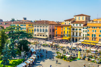 People are strolling among flower stands during Saturday market on the piazza bra in the Italian city Verona