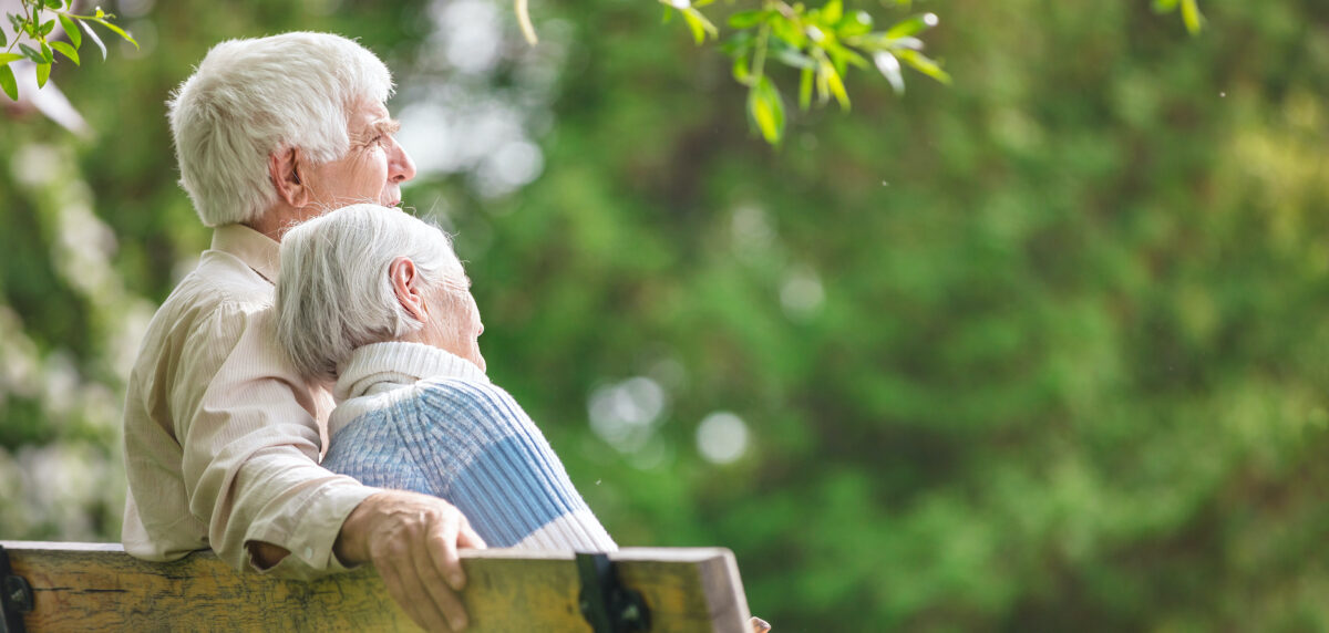 Elderly couple resting on a bench in the park