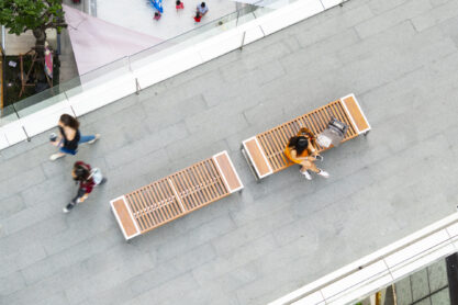 top aerial view fashion woman with shopping bag uses smartphone sit on wooden bench at walkway pedestrian with blur people are walking, , concept of social still life with technology and lifestyle