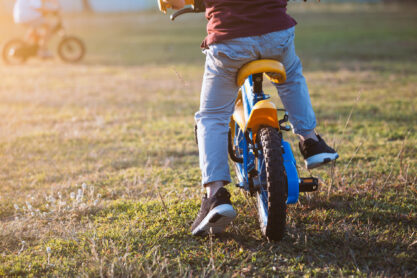 Cute asian child boy having fun to ride a bicycle in the park