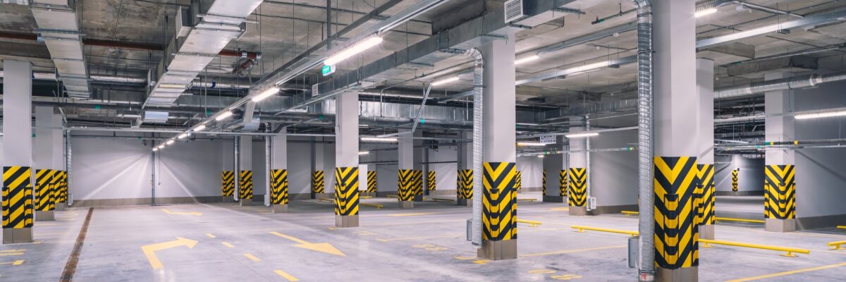 Empty underground parking lot or garage interior with concrete stripe painted columns