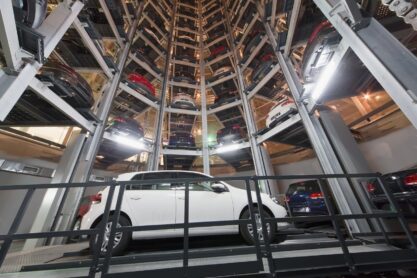 Bottom view of a white car on parking lot with a multi-story automated car parking system