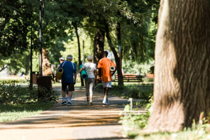 selective focus of senior and multicultural pensioners holding fitness mats and walking in park