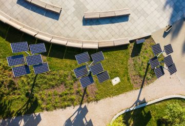 Green energy Aerial flight in a city park overlooking a panel with solar cells surrounded by trees. Nature Ecology Concept. View from the drone on the solar panels. Warsaw, Poland.