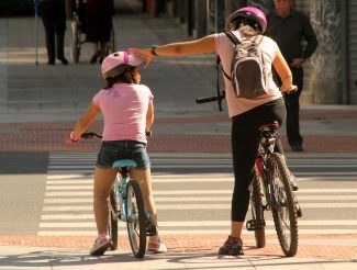 Madre e hija en bicicleta por la ciudad