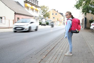 Schulkind möchte eine belebte Strasse überqueren