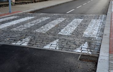 navigation tactile tiles strip for blind and disabled pedestrians who have vision problems. The red pavement has protrusions that lead the person to the crossing and draw attention to the edge road