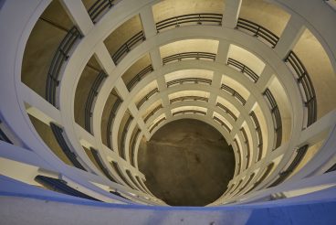 view from above into a circular parking ramp made of concrete