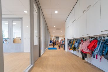 Cloakroom with coats and backpacks in a school building for toddlers and young children