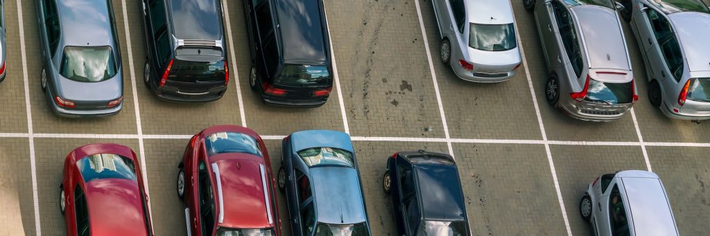 aerial view on parking lot of diferent cars on asphalt places near office or supermarket outdoors